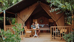 A tented accommodation with a wooden deck, a dining table, and chairs. - Château Léognan, Domaine viticole - proche Bordeaux (Leognan)