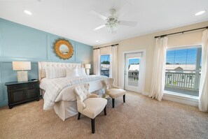 A bedroom with a bed, two chairs, a nightstand, a ceiling fan, and a view of the outside. - HUGE Private Pool w/ 6 seater Cart 4 bikes, 4 min to Beach, 3 hole Putting Green (Santa Rosa Beach)