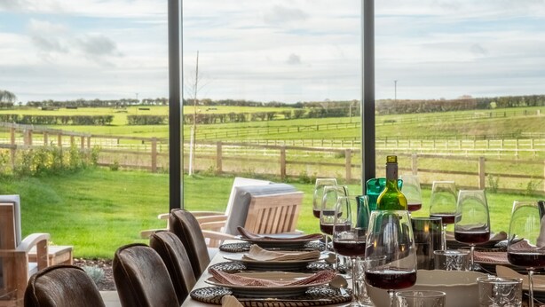A table set for dining with a view of a grassy field and a wooden fence. - Hayloft, Burnham Market, Norfolk (Burnham Market)