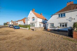 A residential street with houses, gravel driveways, and parked cars. - Golf Cottage, West Runton, Norfolk (West Runton)