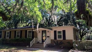 A single-story house with a front porch and a staircase leading to the entrance. - Pet-friendly Cottage in the Trees - GREAT location! (Fernandina Beach)