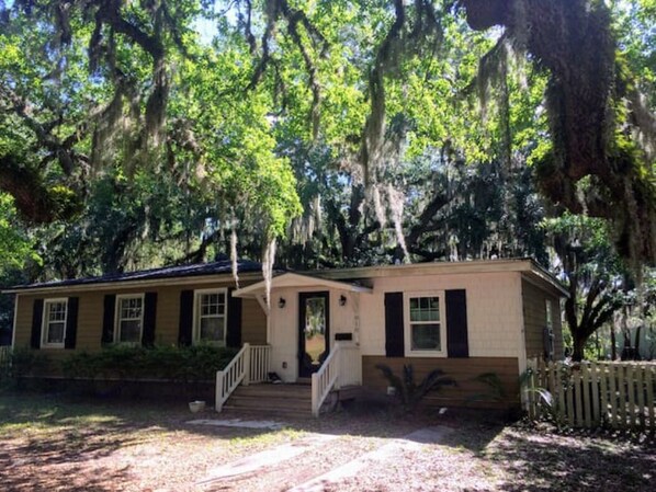 A single-story house with a front porch and a staircase leading to the entrance. - Pet-friendly Cottage in the Trees - GREAT location! (Fernandina Beach)