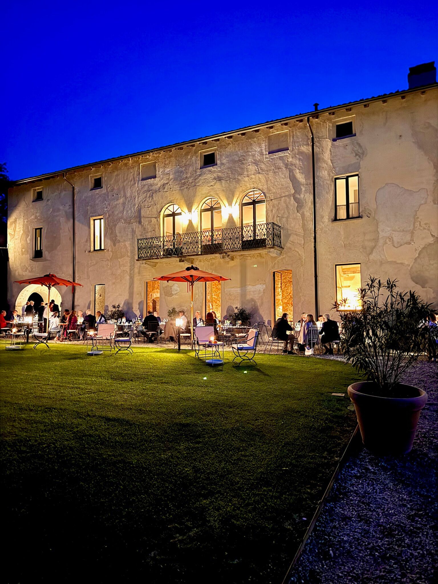 Un edificio con patio, mesas al aire libre y una entrada bien iluminada.