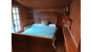 Ein schlicht eingerichtetes Schlafzimmer im Chalet-Stil mit einem Einzelbett, einem Fenster und einer Heizung.