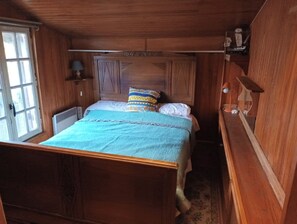 Une chambre de style cabane en bois, avec un lit simple, une fenêtre et un radiateur.