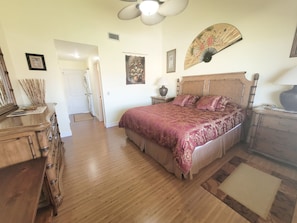 A bedroom with a large bed, wooden dresser, and a ceiling fan. - SH 149.Ocean View Townhouse with great pool and ocean view. (St. Augustine)