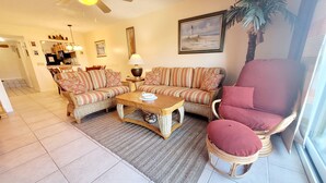 A living room with wicker furniture, a ceiling fan, and a painting on the wall. - SH 149.Ocean View Townhouse with great pool and ocean view. (St. Augustine)