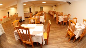 A dining area with multiple tables and chairs, arranged in rows. - Hotel Financial Ltda (Belo Horizonte)