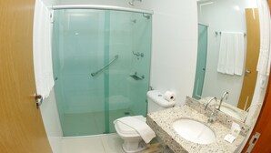 A modern bathroom with a glass-enclosed shower, a white toilet, and a granite countertop sink. - Hotel Financial Ltda (Belo Horizonte)