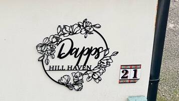 A wall with a decorative metal sign that reads 'Dapp's Hill Haven' and a small sign indicating the number 21.