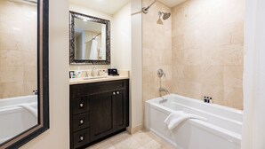 Un baño moderno con bañera, ducha y tocador con espejo.