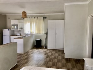 A compact kitchen with a microwave, toaster, sink, and cabinets. - 1 bed apartment in Mount Pleasant Heights - 2013 (Harare)