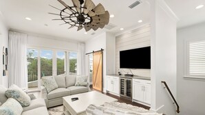 A modern living room with a sofa, coffee table, and a TV mounted on the wall.