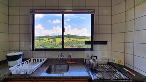 Una cocina con un amplio ventanal que ofrece vistas a un paisaje verde.