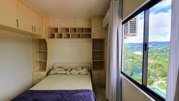 Una camera da letto con un letto, una finestra vista paesaggio ed elementi a parete.