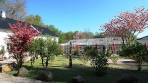 A building with a garden area featuring cherry blossom trees and a lawn. - Fantastic vacation right on the Baltic Sea coast of Southern Jutland, Broagerland (Broager)