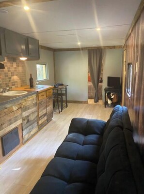 Cozy living space with a kitchenette, sofa, and TV.