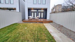 Una casa moderna con un patio y dos sillas.
