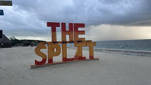 Un letrero de playa con las palabras "THE SPLIT" y decoraciones de animales.