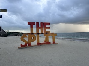 Un letrero de playa con las palabras "THE SPLIT" y decoraciones de animales.