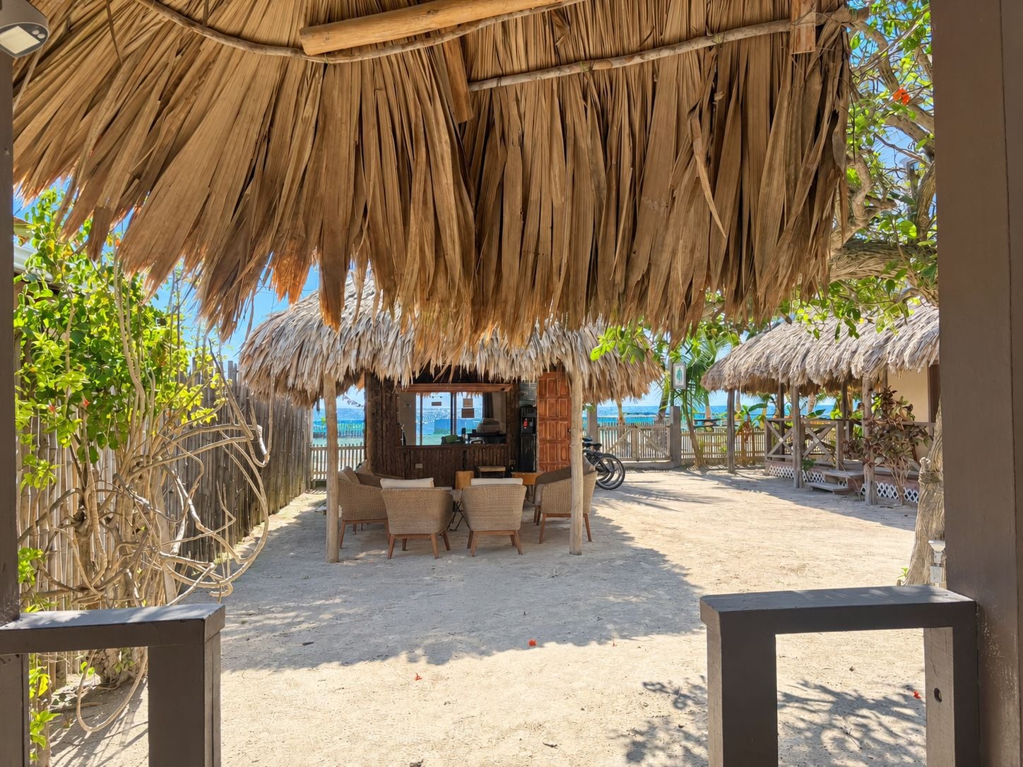 A beachside hut with a thatched roof, a bar area, and outdoor seating.