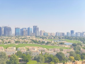 A cityscape with high-rise buildings and a golf course.