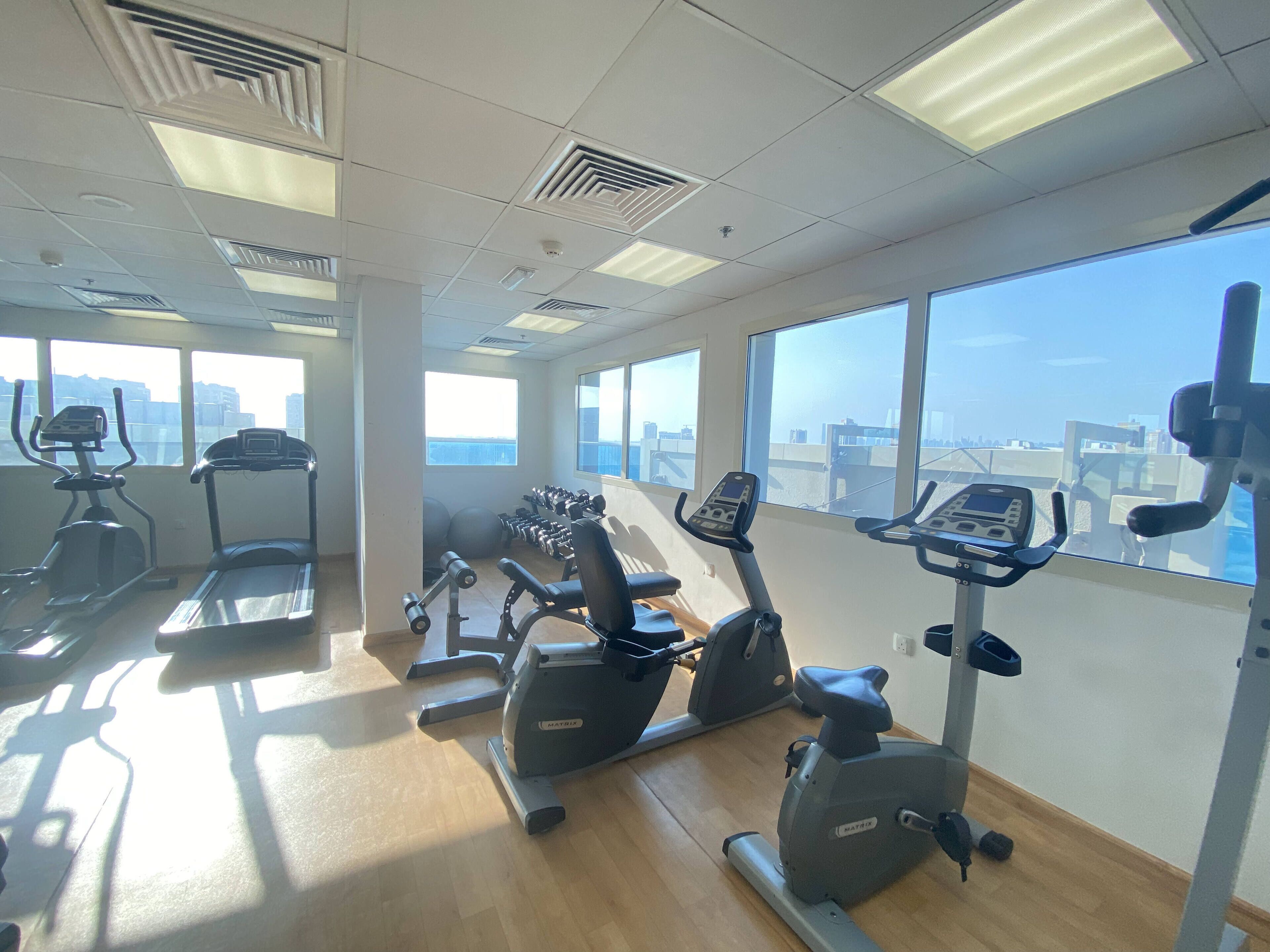 A gym with treadmills, elliptical machines, and free weights.