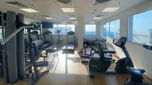 A gym with treadmills, elliptical machines, and weight equipment. - Lux BnB Elite Residences I Golf Course Views (Dubai)