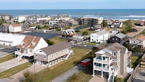 A coastal residential area with houses, a beach, and a clear view of the ocean. - Another Day In Paradise: 4-Min Walk to the Beach! (Kill Devil Hills)