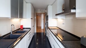Une cuisine moderne avec des plans de travail noirs, des armoires blanches et des appareils électroménagers en acier inoxydable.