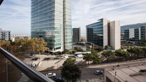 Un paysage urbain moderne avec de hauts immeubles, un ciel dégagé et un passage piéton.