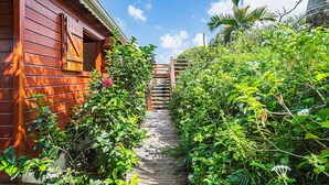 A wooden staircase leading to a building surrounded by lush greenery.
