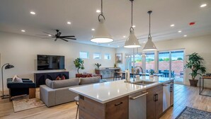 A modern kitchen with a central island, pendant lighting, and a ceiling fan. - Arcadia 62 | Sleeps 26 * GAMES GALORE! * Private Hot Tub (Santa Clara)