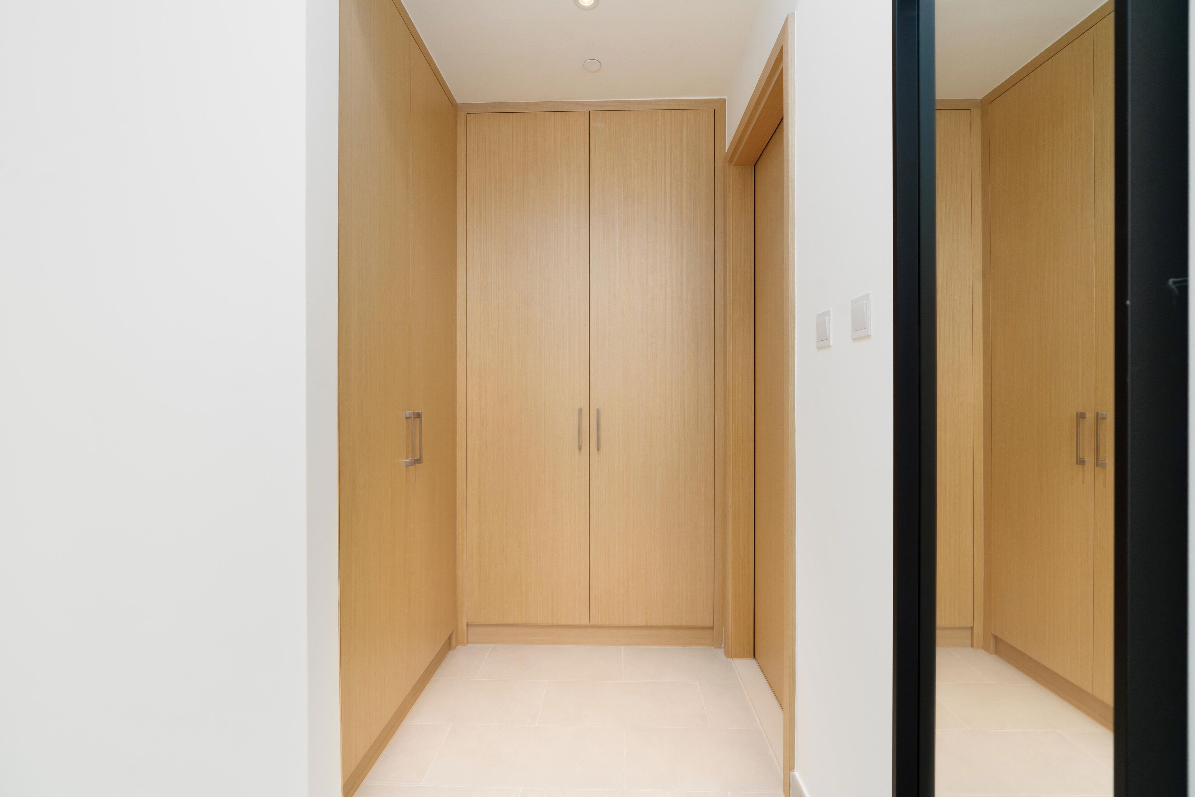 Un pasillo con un armario de madera y una puerta.