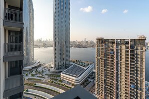 Un edificio alto de diseño moderno, con varios balcones y vista al paseo marítimo.