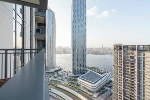Un edificio de gran altura con diseño moderno, que presenta una fachada curva y un jardín en la azotea.