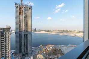 Un edificio alto con vista al frente marítimo y a una zona de construcción.