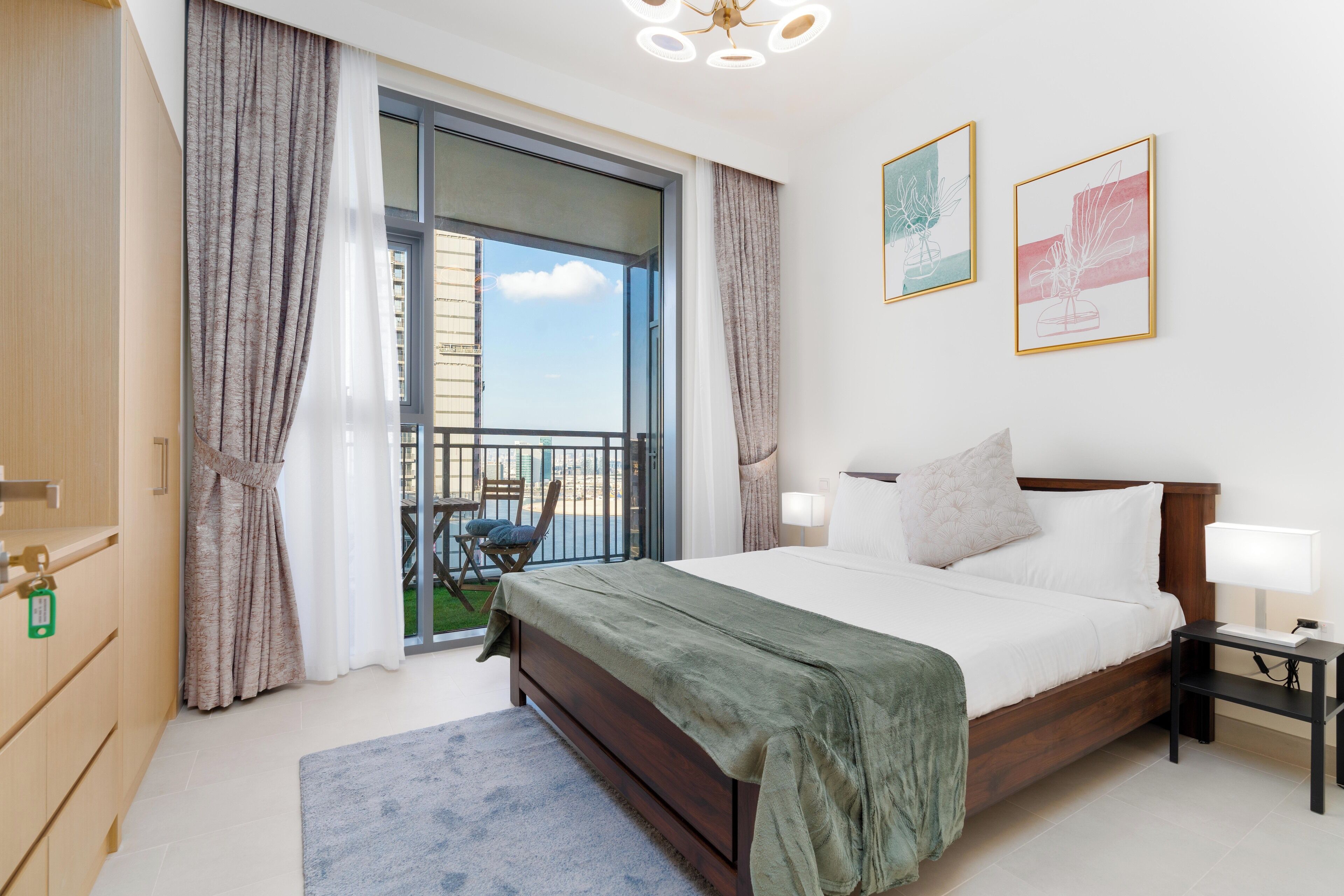 Un dormitorio con una cama grande, una mesita de noche, una ventana con cortinas y vistas al exterior.