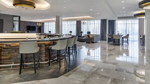 Una cocina moderna con una isla curva, taburetes de bar y un amplio ventanal que proporciona luz natural.