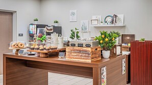 A bakery counter with pastries, a coffee machine, and a sign reading "Happy Customers".