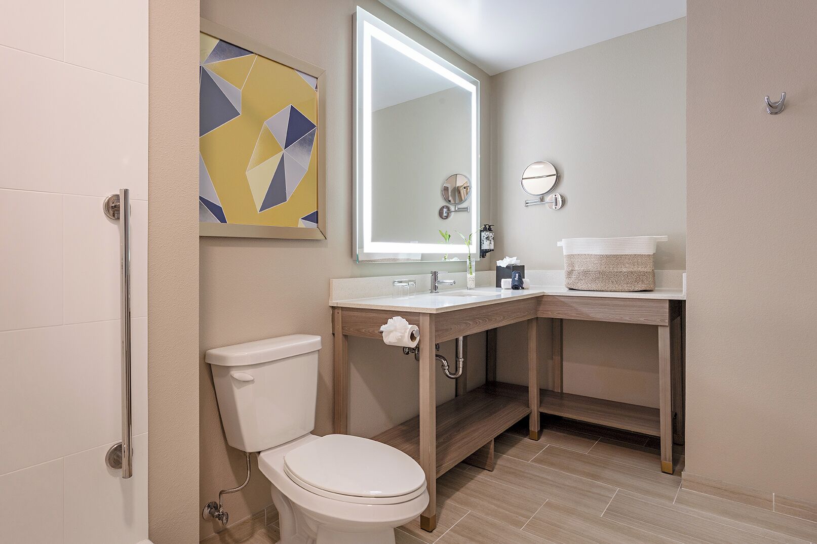 A modern bathroom with a toilet, sink, and mirror.