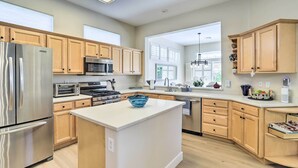 Une cuisine moderne avec des meubles en bois, des appareils en acier inoxydable et un îlot central.