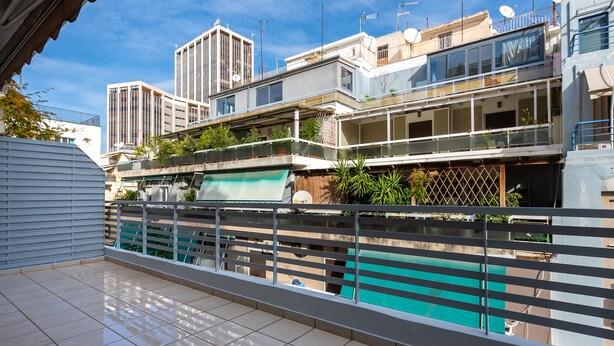 Un edificio residenziale con diversi balconi, una piscina e antenne paraboliche sul tetto.