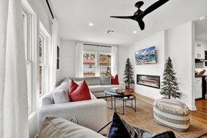 Una sala de estar moderna con sofá, mesa de centro y chimenea.