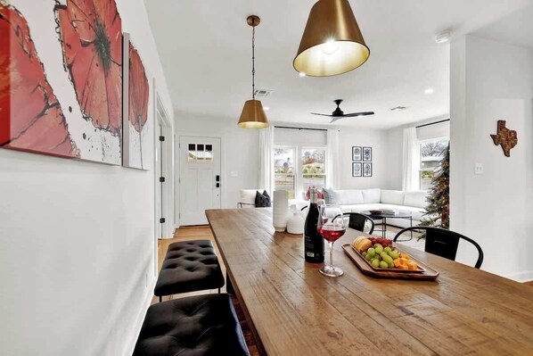 Un comedor moderno con una mesa de madera, bancos y una bandeja de fruta.