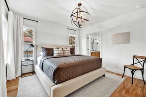 Un dormitorio moderno con una cama grande, un escritorio y una silla.