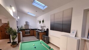 A pool table with balls, a kitchen area, and a 'No Smoking' sign. - Ty Glas Mews (2 beds) (Cardiff)