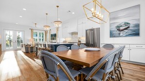 A spacious kitchen with white cabinets, a large island, and a stainless steel refrigerator. - Gather. Laugh. Repeat. Luxury in BMB – Bikes Included, Golf Cart Available (Santa Rosa Beach)