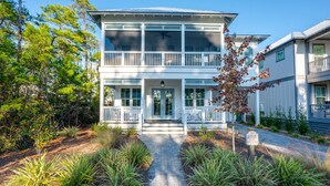A two-story building with a covered porch and a central entrance. - Gather. Laugh. Repeat. Luxury in BMB – Bikes Included, Golf Cart Available (Santa Rosa Beach)
