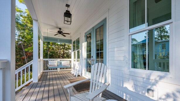 A wooden porch with a ceiling fan, a rocking chair, and a small table. - Gather. Laugh. Repeat. Luxury in BMB – Bikes Included, Golf Cart Available (Santa Rosa Beach)